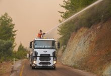 Bombeiros usam um canhão de água montado em um caminhão para combater um incêndio florestal.