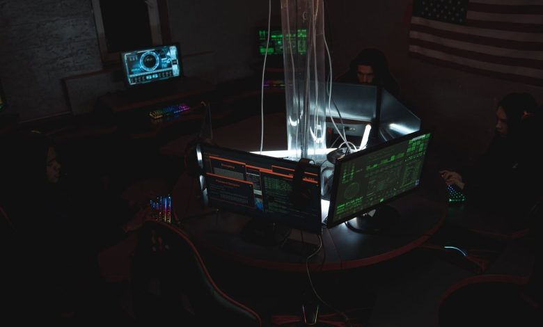 Equipe de profissionais de cibersegurança trabalha diante de computadores em uma sala de monitoramento.