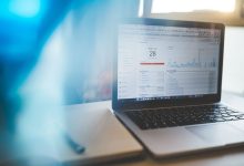 Laptop exibindo um painel de análise digital em uma mesa de trabalho moderna.