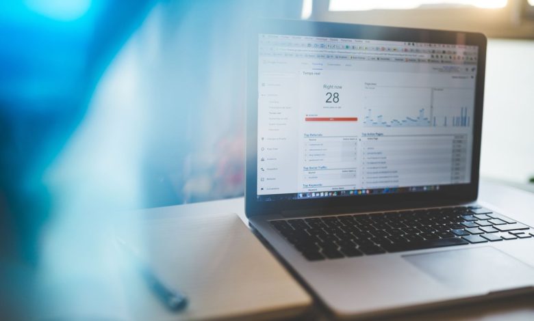 Laptop exibindo um painel de análise digital em uma mesa de trabalho moderna.