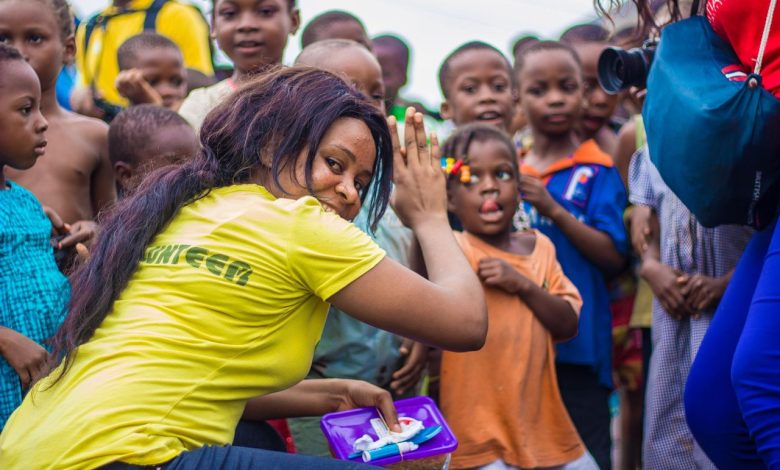 Crianças e voluntários participam de uma atividade comunitária ao ar livre.